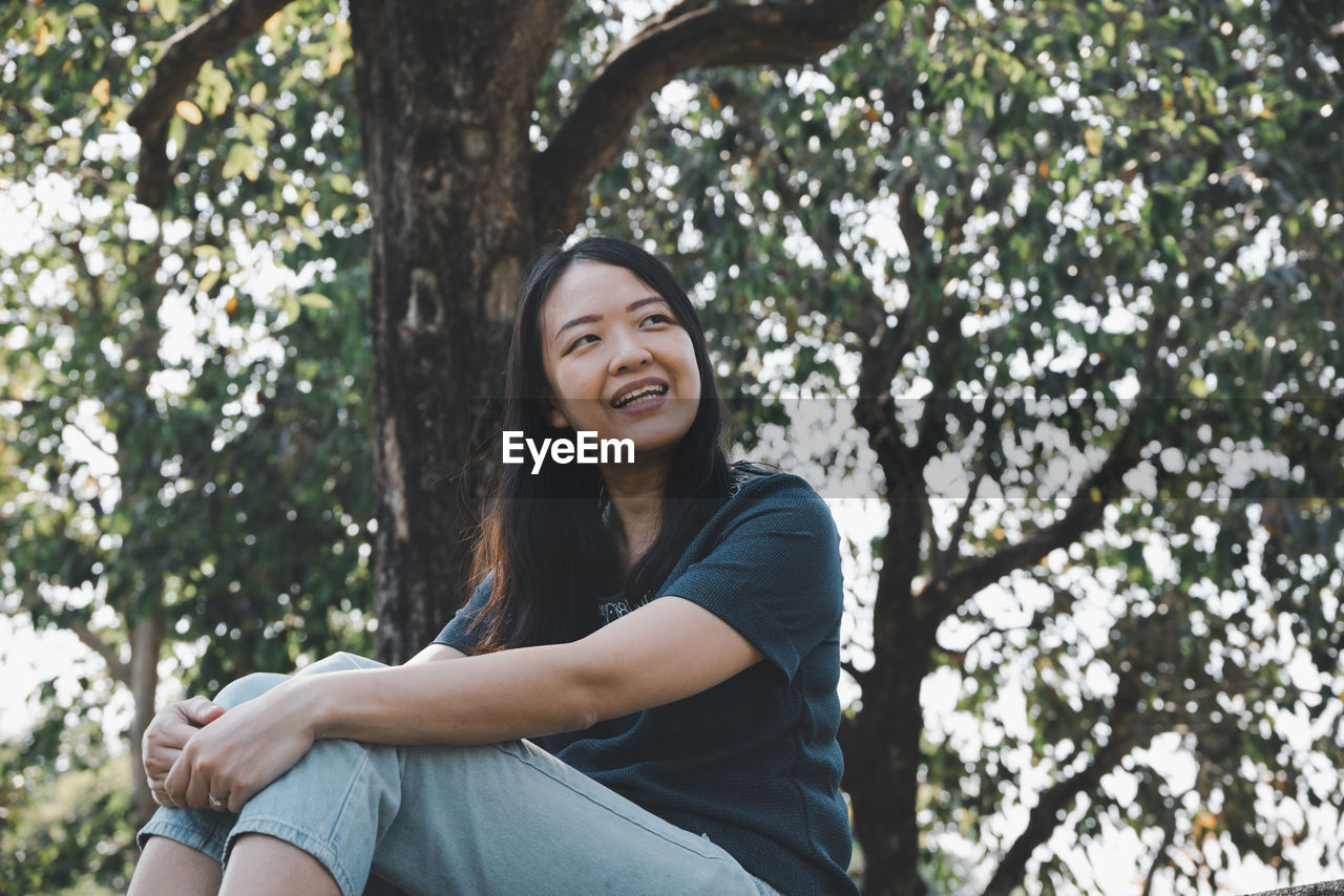 Asian little daughter hug her mom with smile in the park. 