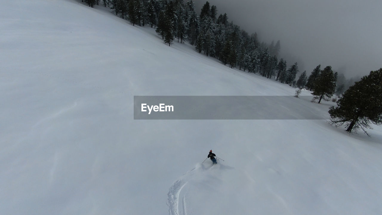 PERSON SKIING ON SNOWCAPPED MOUNTAIN