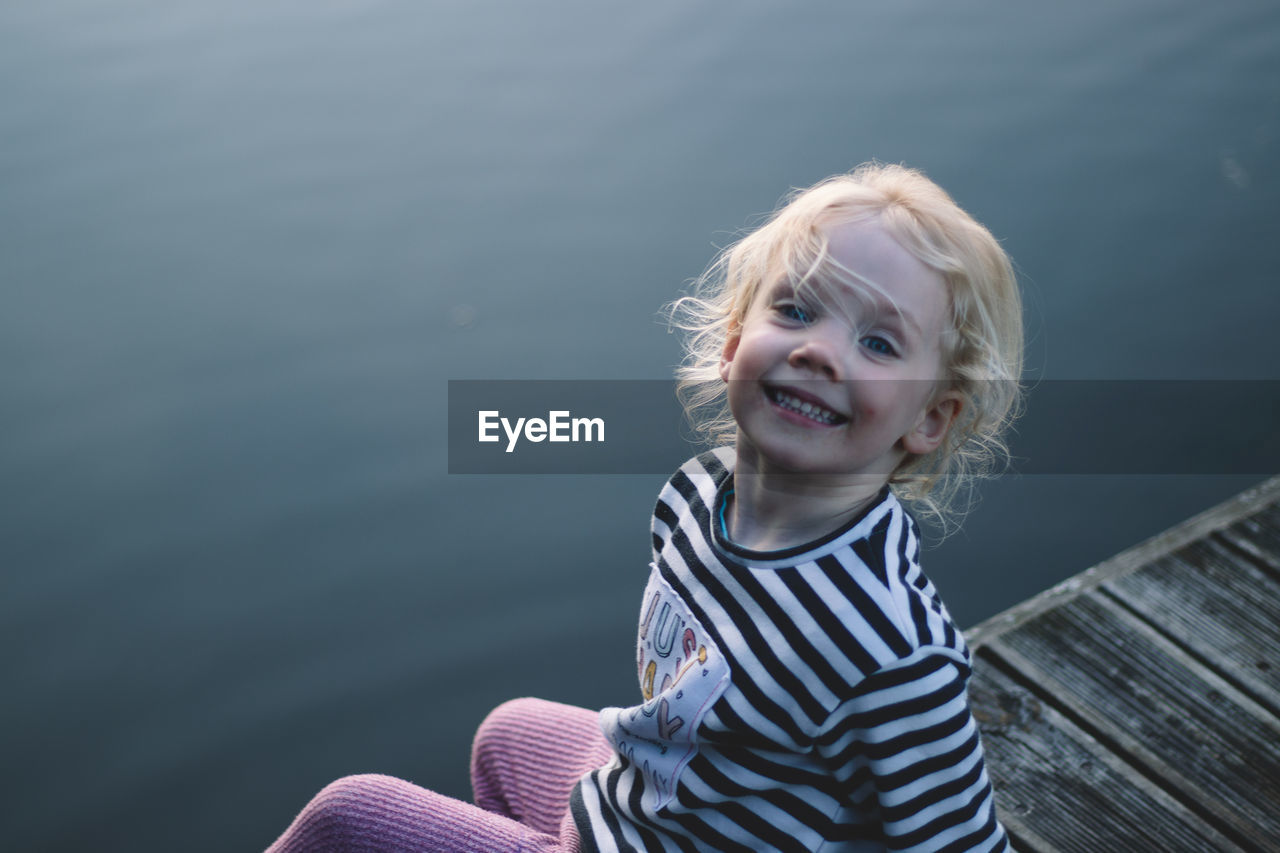 Portrait of smiling girl against water