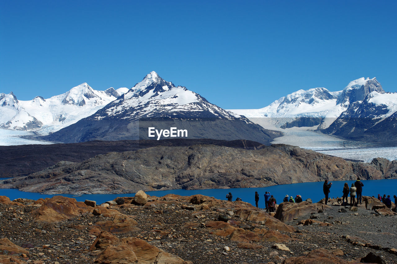 Scenic view of snowcapped mountains against clear blue sky