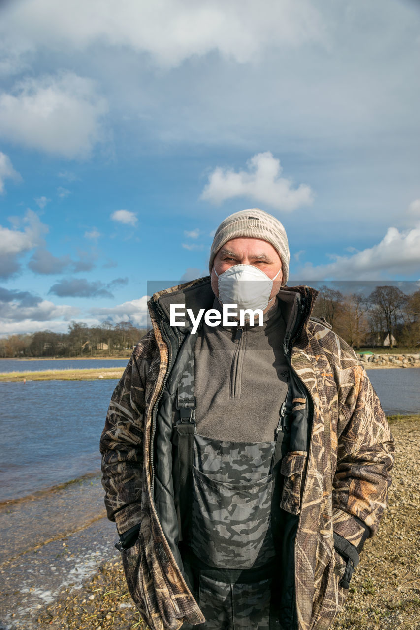 Photo with a portrait of a man, on the face is a protective mask, spring