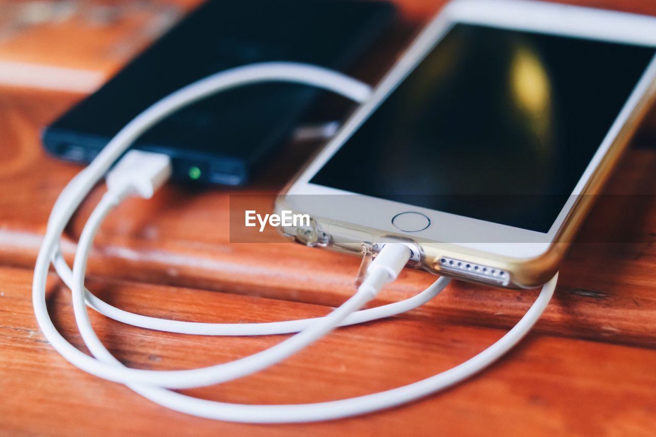 High angle view of mobile phone on wooden table