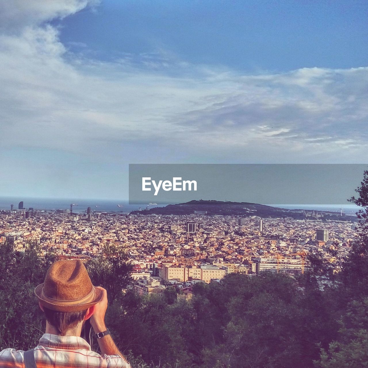 REAR VIEW OF WOMAN LOOKING AT CITYSCAPE