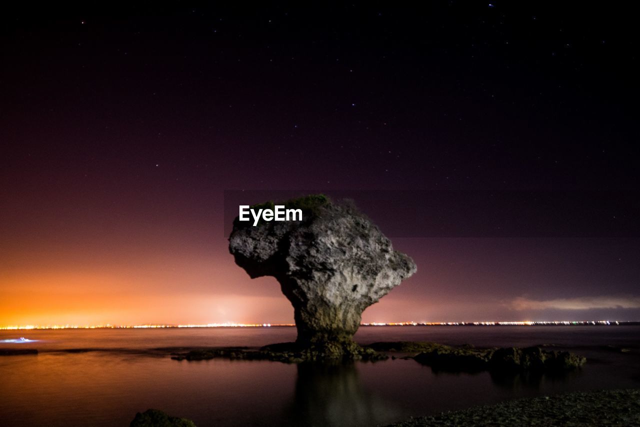 Rock by sea against sky at night in taiwan