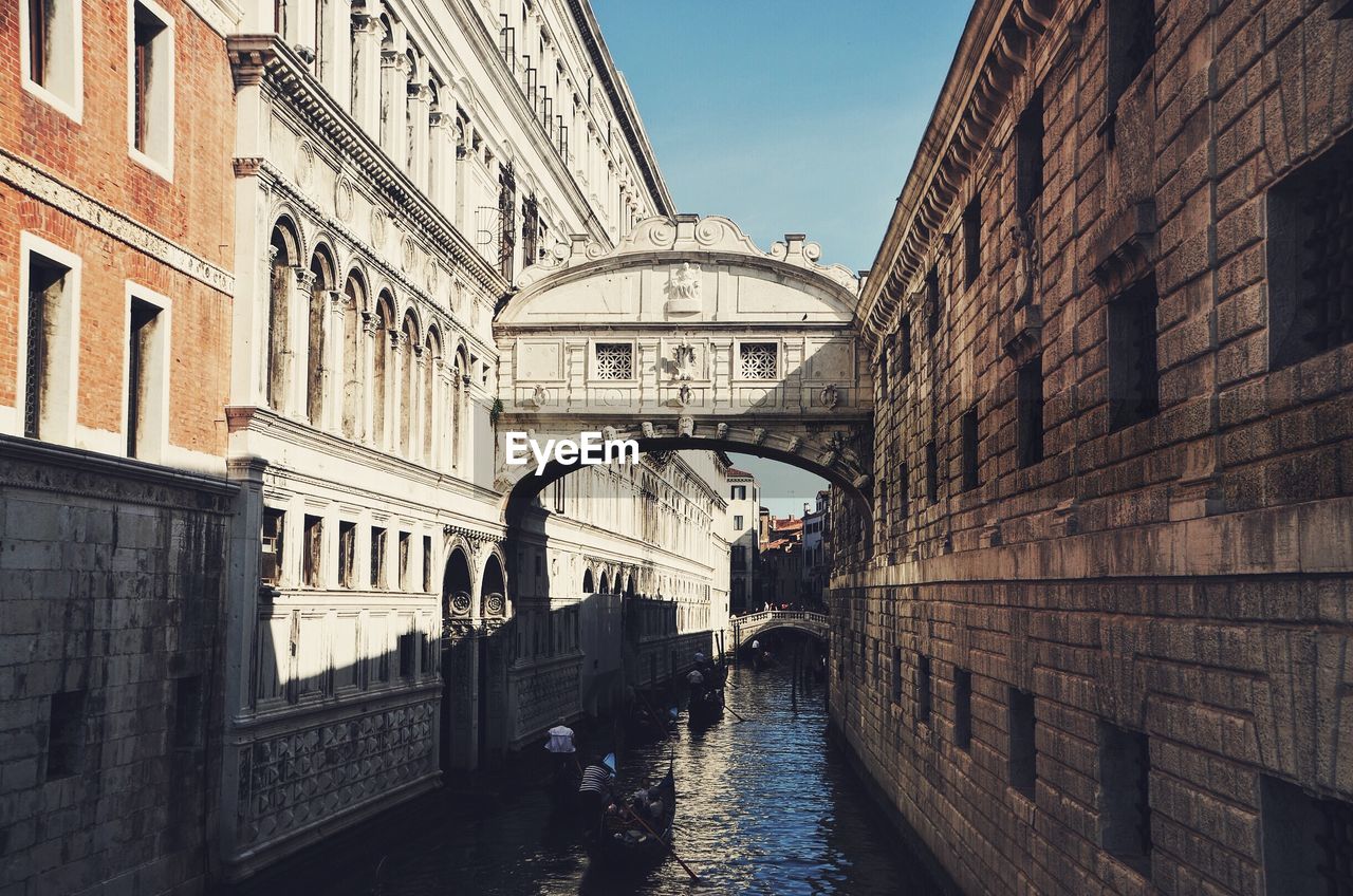 Gondolas under the bridge of sighs against clear sky