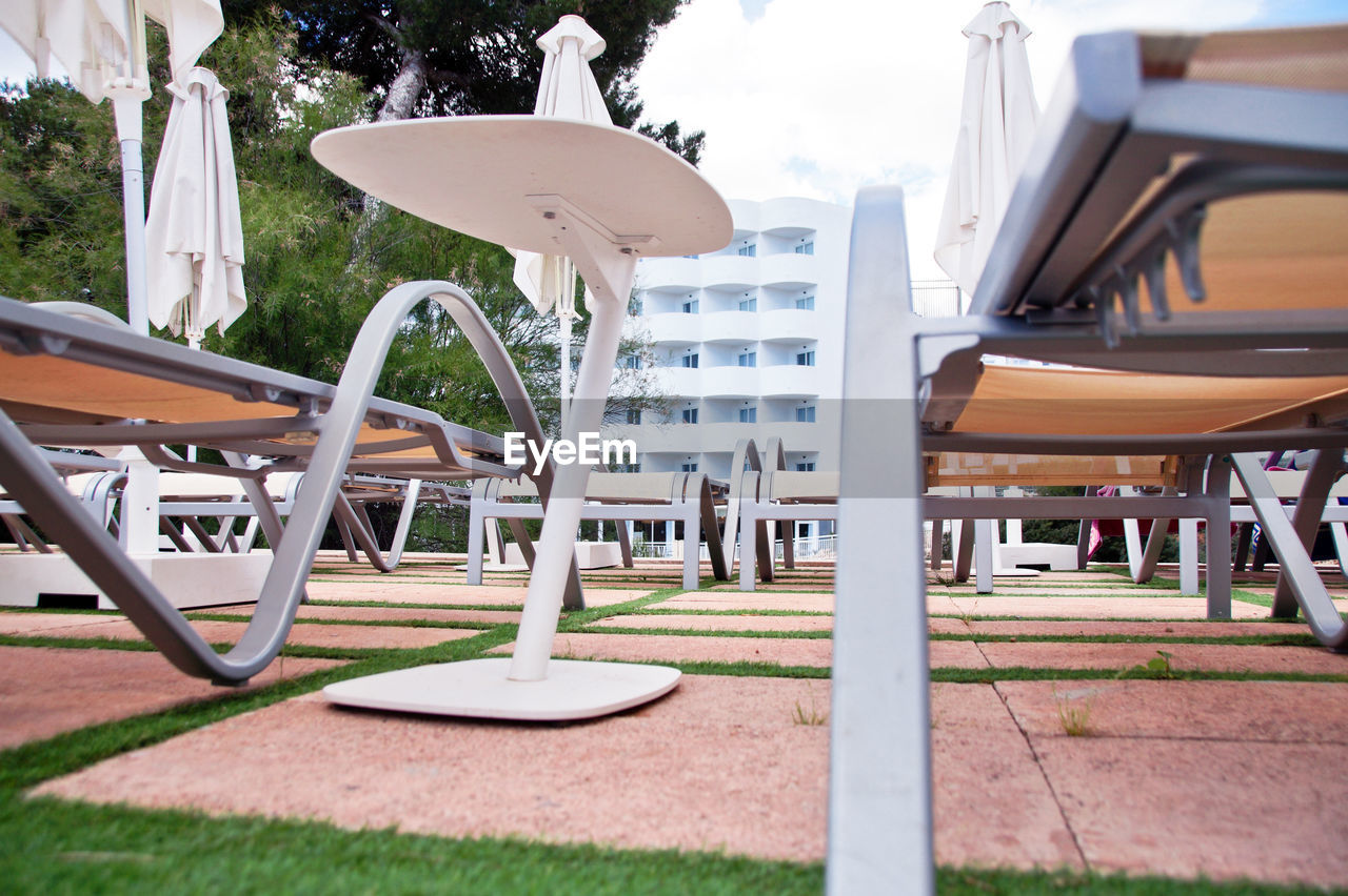 EMPTY CHAIRS AND TABLES IN PARK