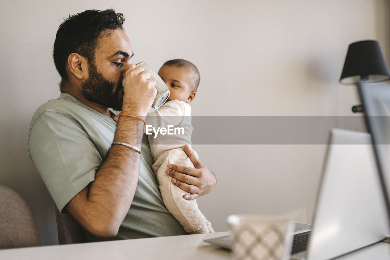 Father with baby working from home