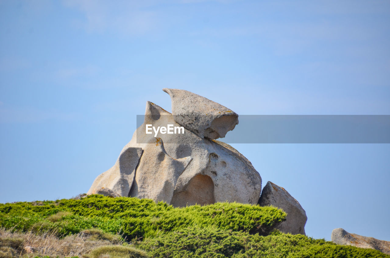 Low angle view of rock against blue sky
