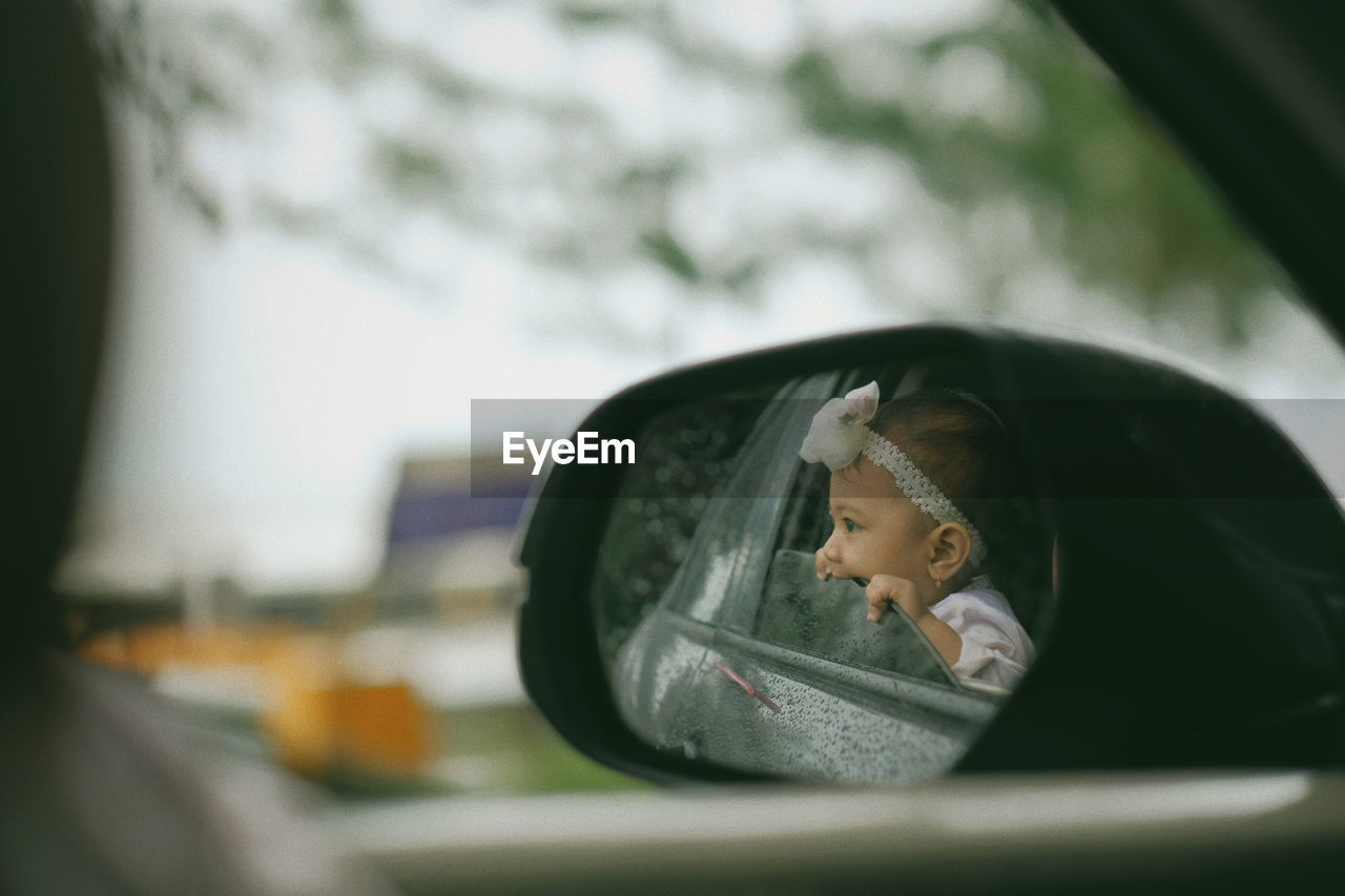 Little baby peeking outside car window 