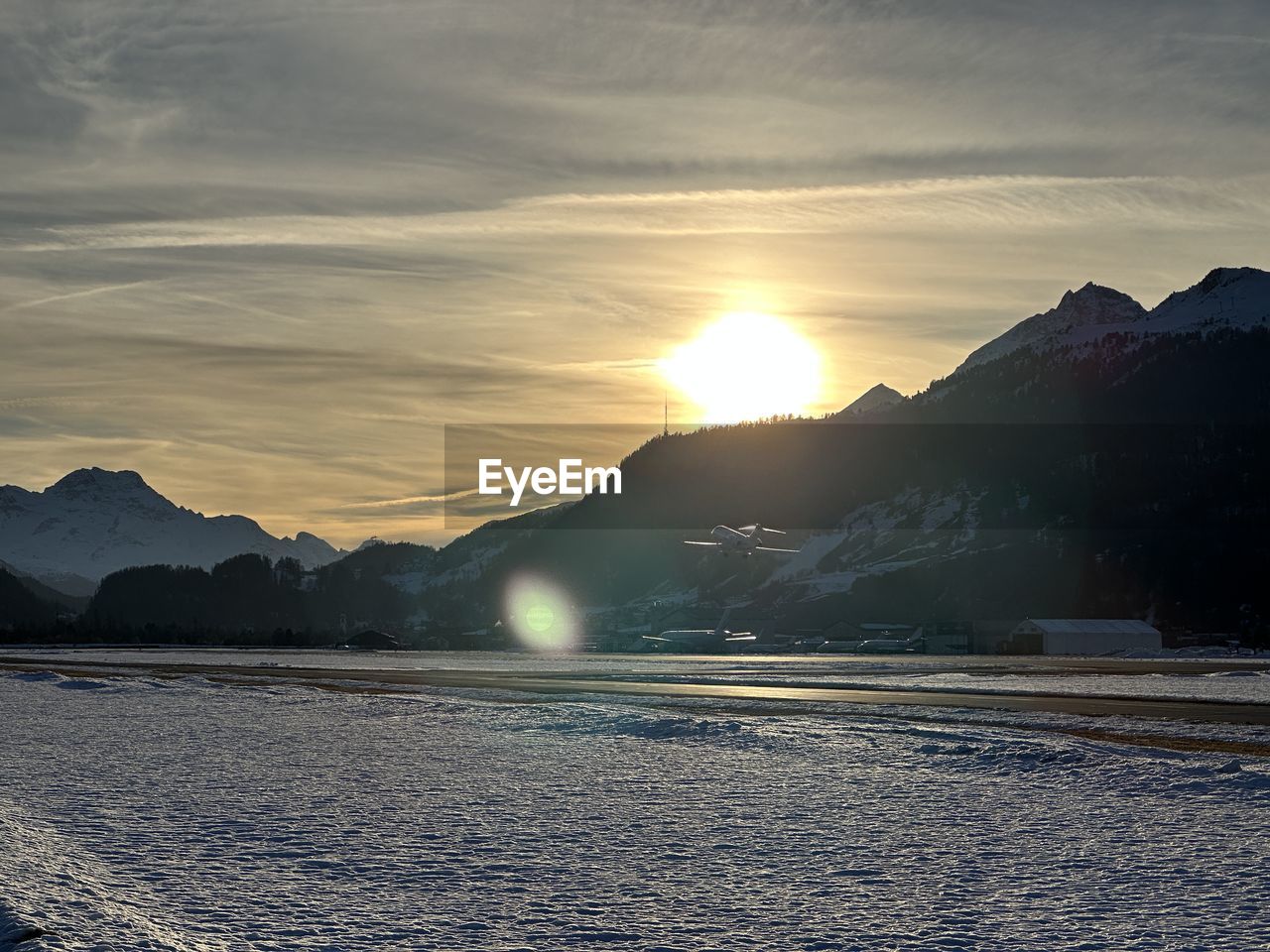 mountain, sky, morning, sunrise, environment, scenics - nature, dawn, landscape, beauty in nature, cold temperature, cloud, snow, nature, mountain range, sunlight, water, winter, sun, horizon, reflection, land, sea, tranquility, no people, tranquil scene, travel, travel destinations, ice, dramatic sky, sunbeam, outdoors, frozen, non-urban scene, idyllic, dramatic landscape