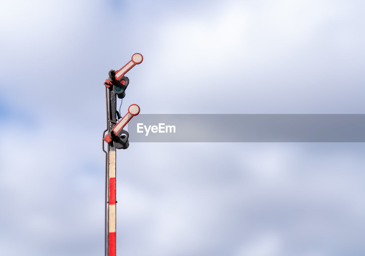 LOW ANGLE VIEW OF RED TELEPHONE POLE AGAINST SKY