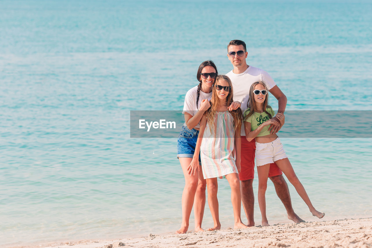 Full length of family standing on beach