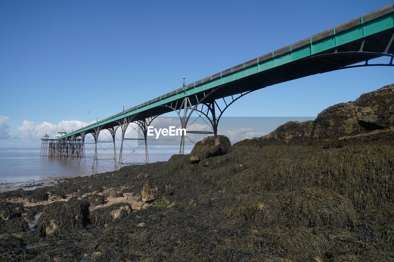 LOW ANGLE VIEW OF BRIDGE OVER RIVER AGAINST CLEAR SKY