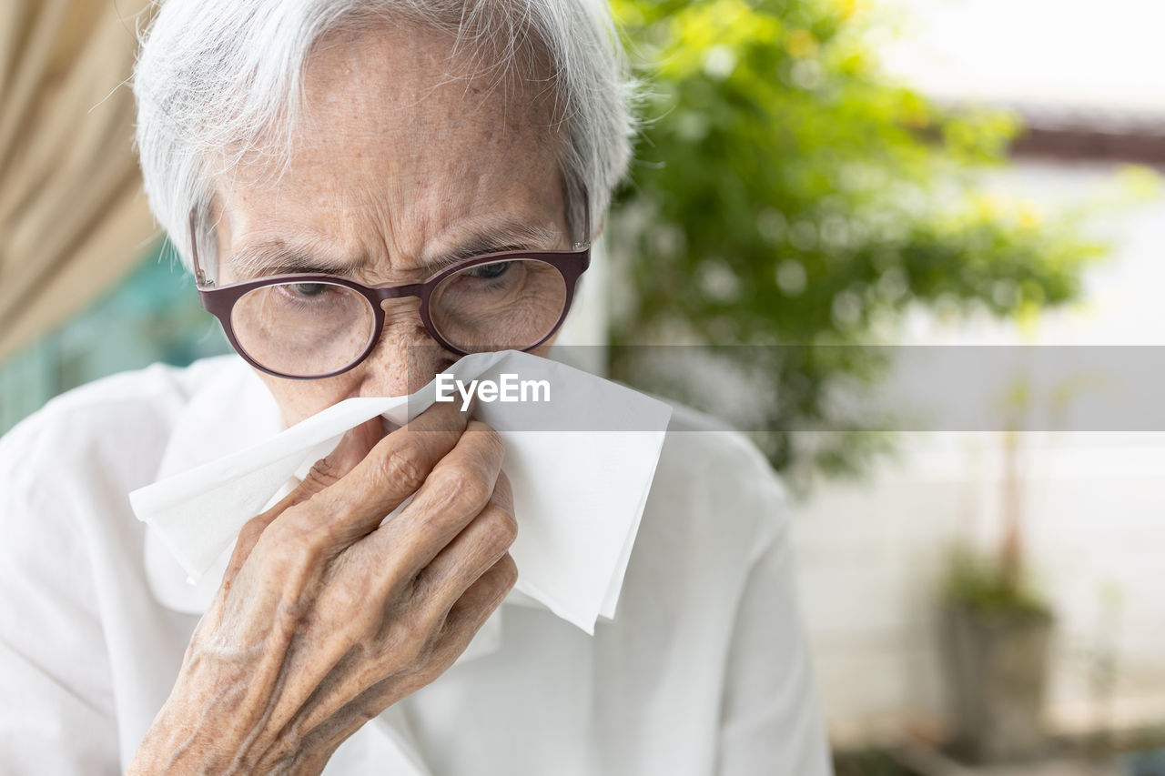 Senior woman blowing nose