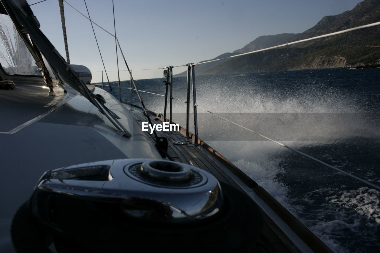 BOAT SAILING ON SEA AGAINST SKY