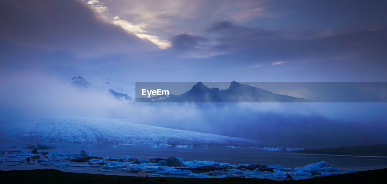 Huge ice glaciers in a water colored by the beautiful sunset