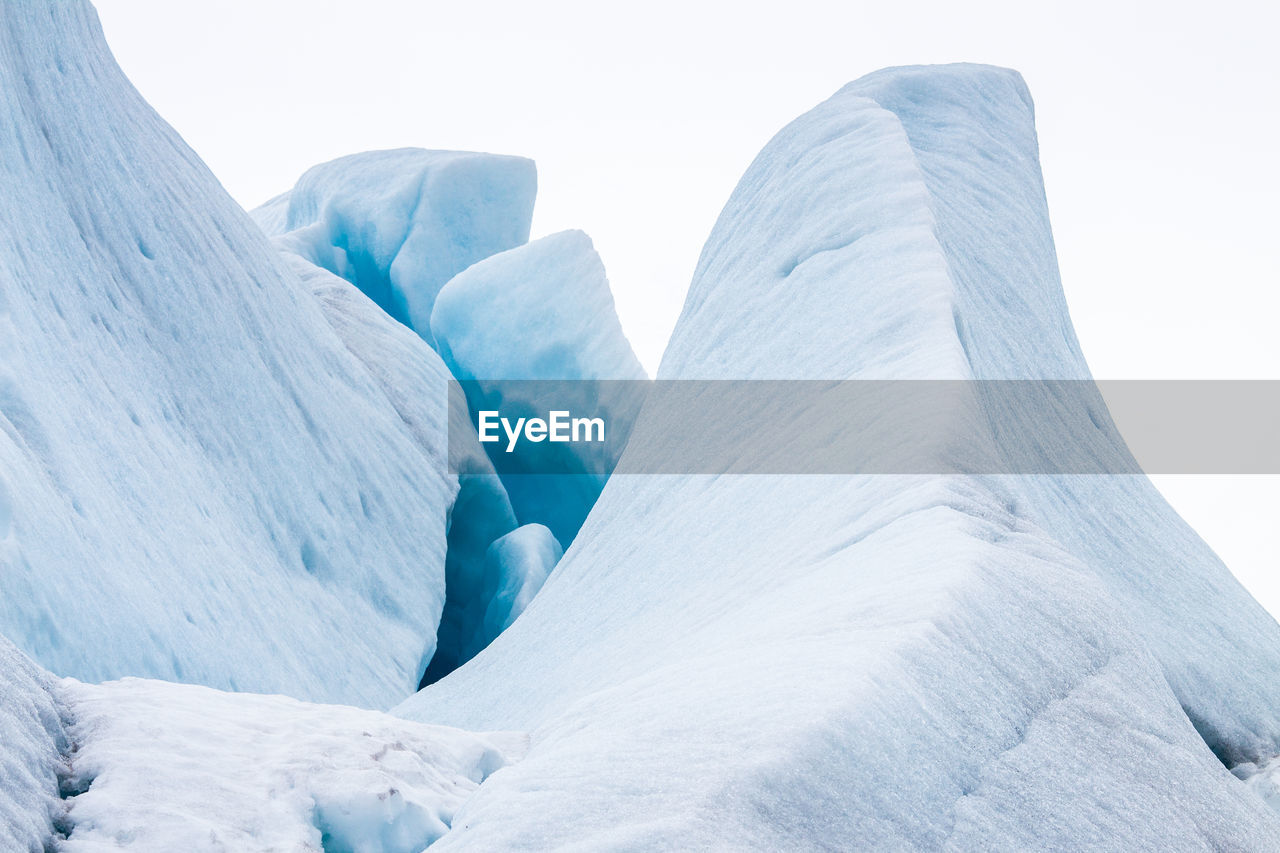 Low angle view of glacier against clear sky