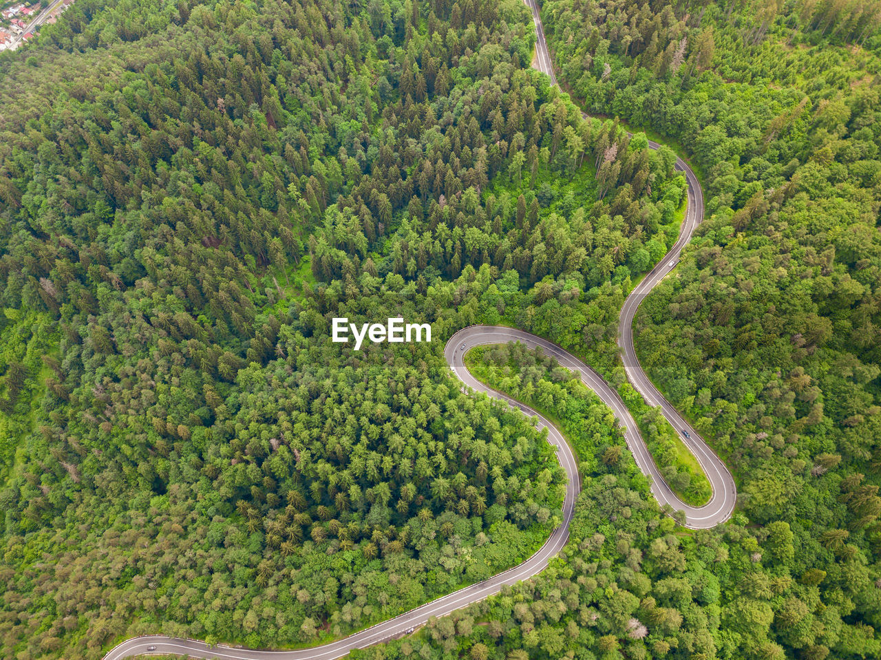 Winding road from high mountain pass, in summer time. aerial view by drone . romania