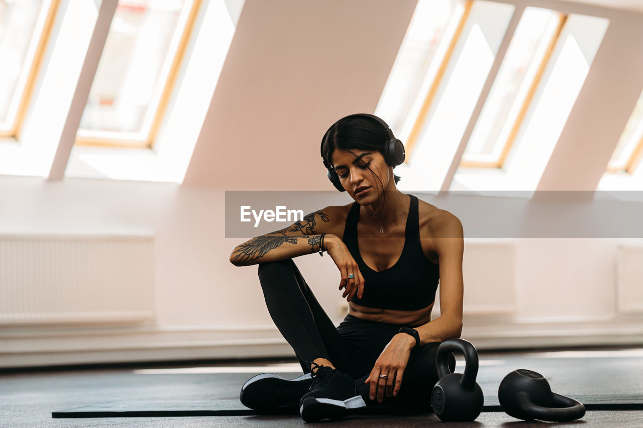 Full length of woman resting at gym