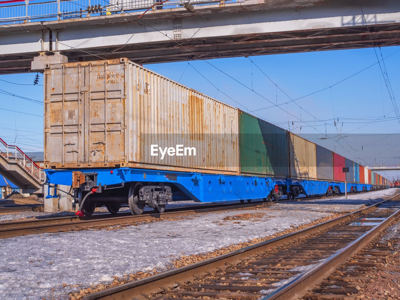 Long freight train of idler flat cars loaded with intermodal 40ft containers on the marshalling yard