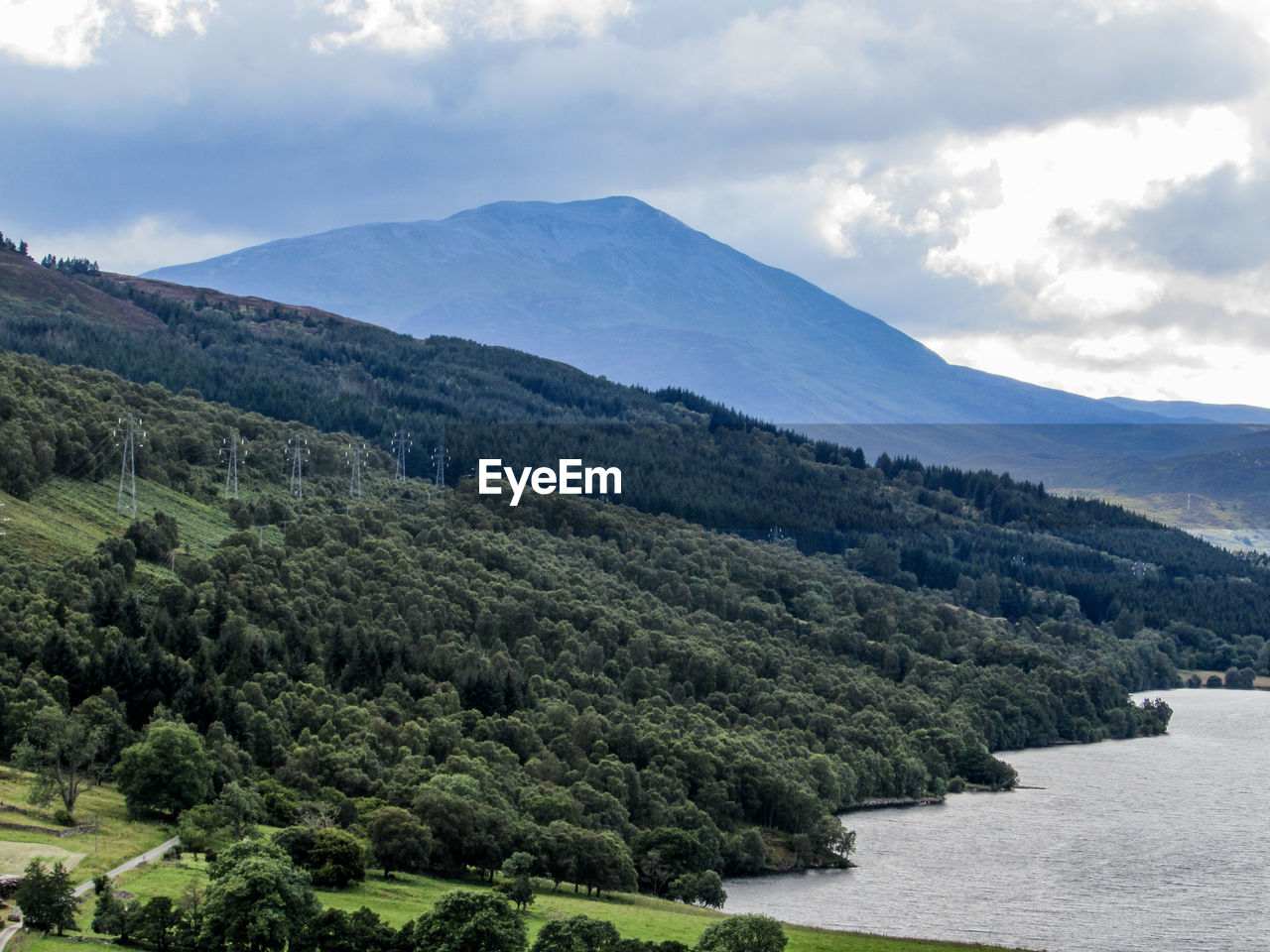 Scenic view of lake and mountains against cloudy sky