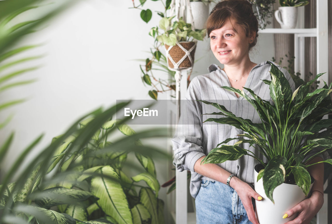 portrait of young woman holding plant