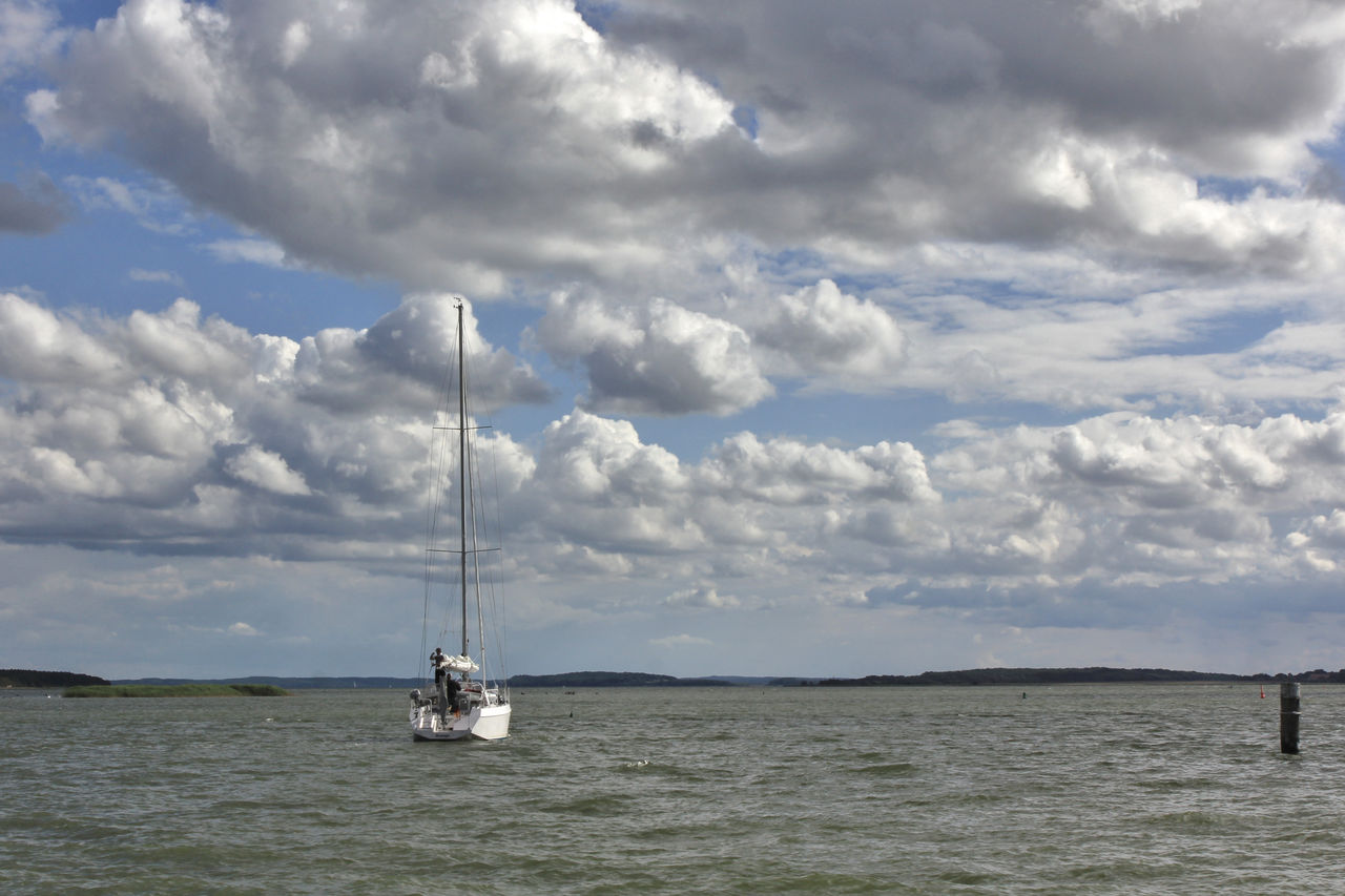 Sailboat in sea against sky