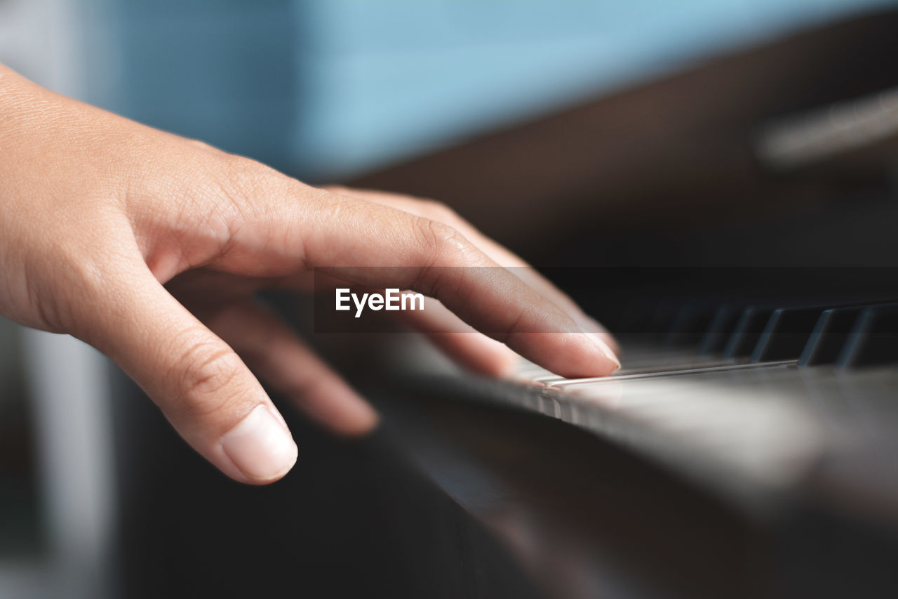 Cropped hand playing piano