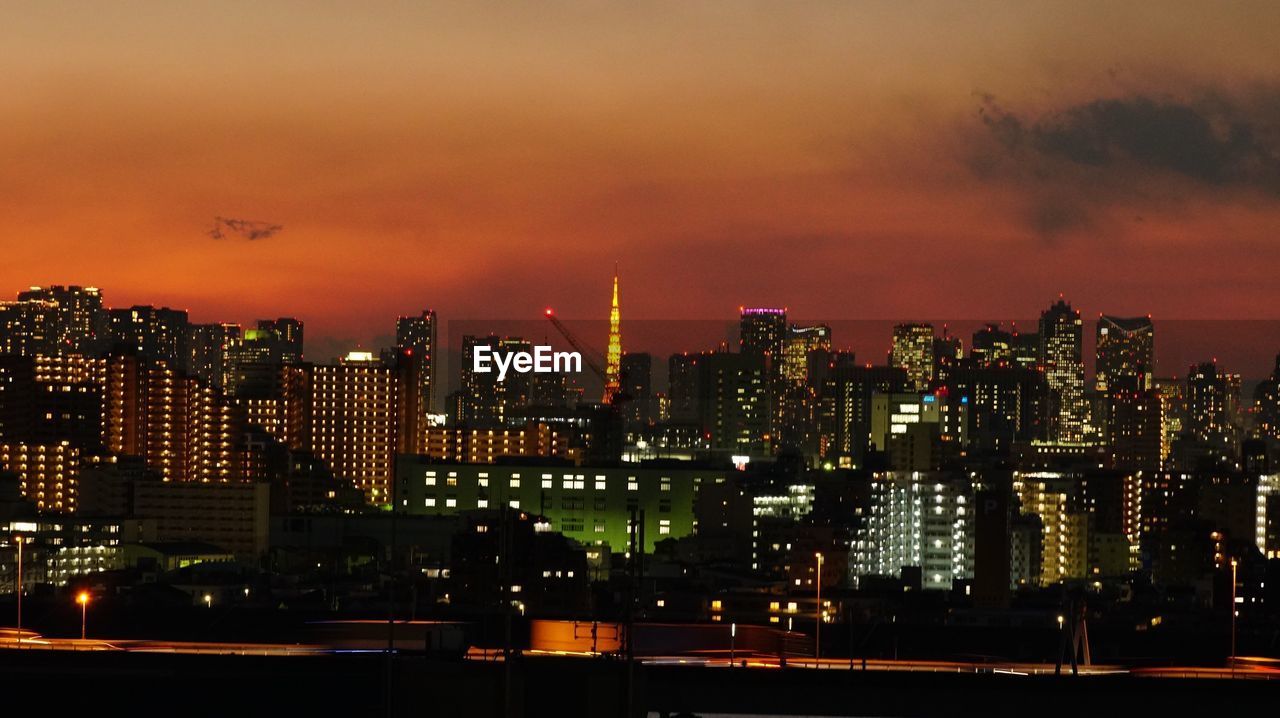 VIEW OF ILLUMINATED CITYSCAPE AT NIGHT