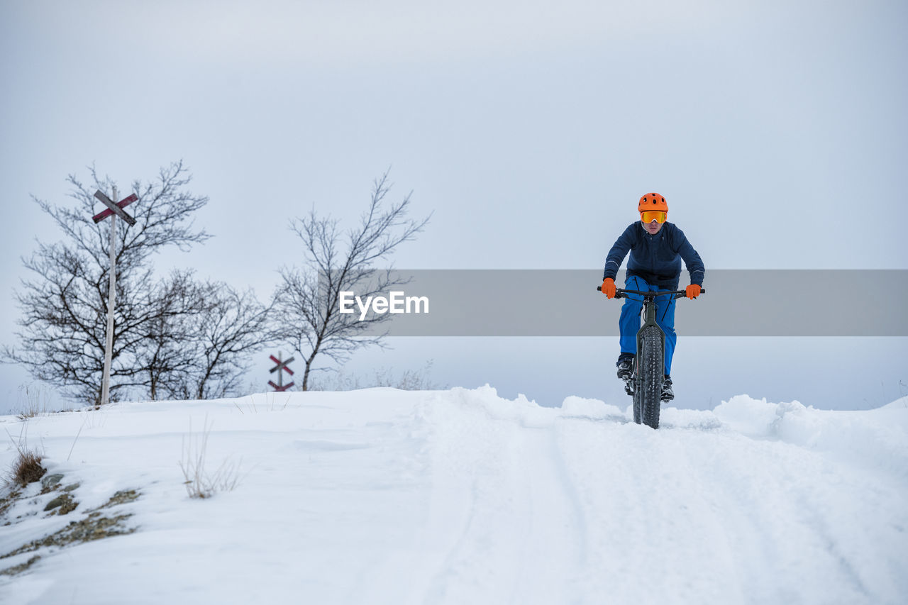 Man cycling in winter landscape