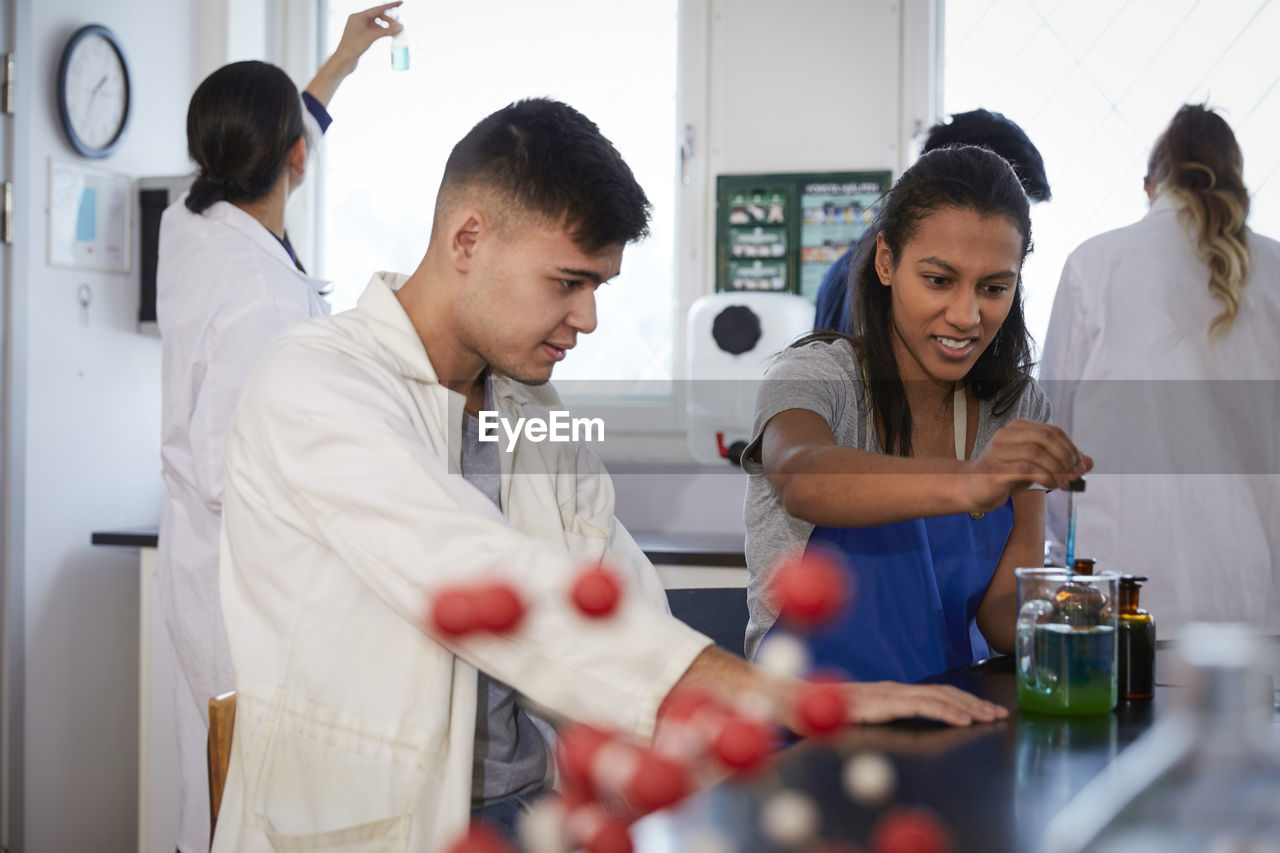 Multi-ethnic chemistry students with teacher in laboratory at university