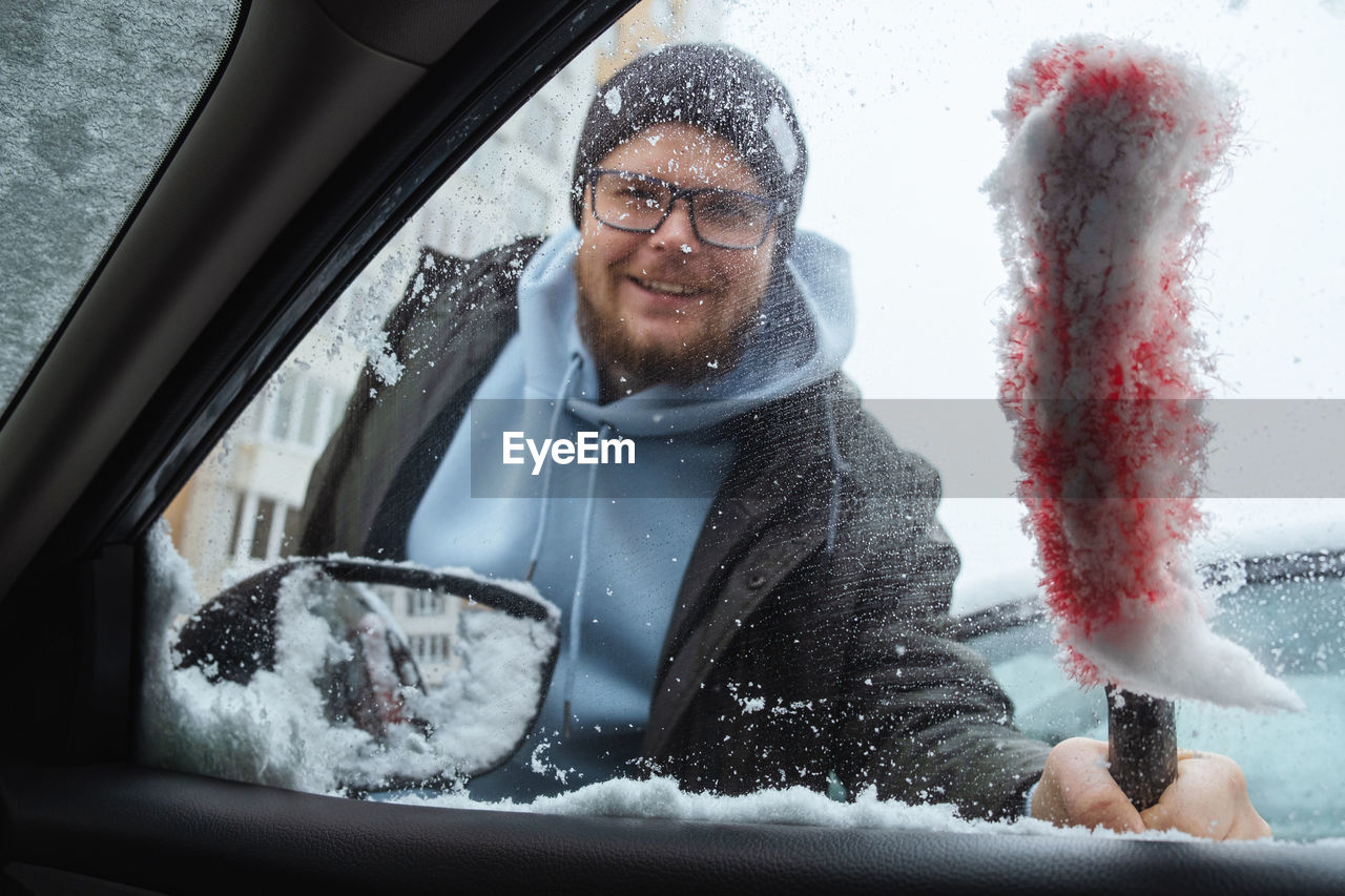 portrait of young woman in car in winter