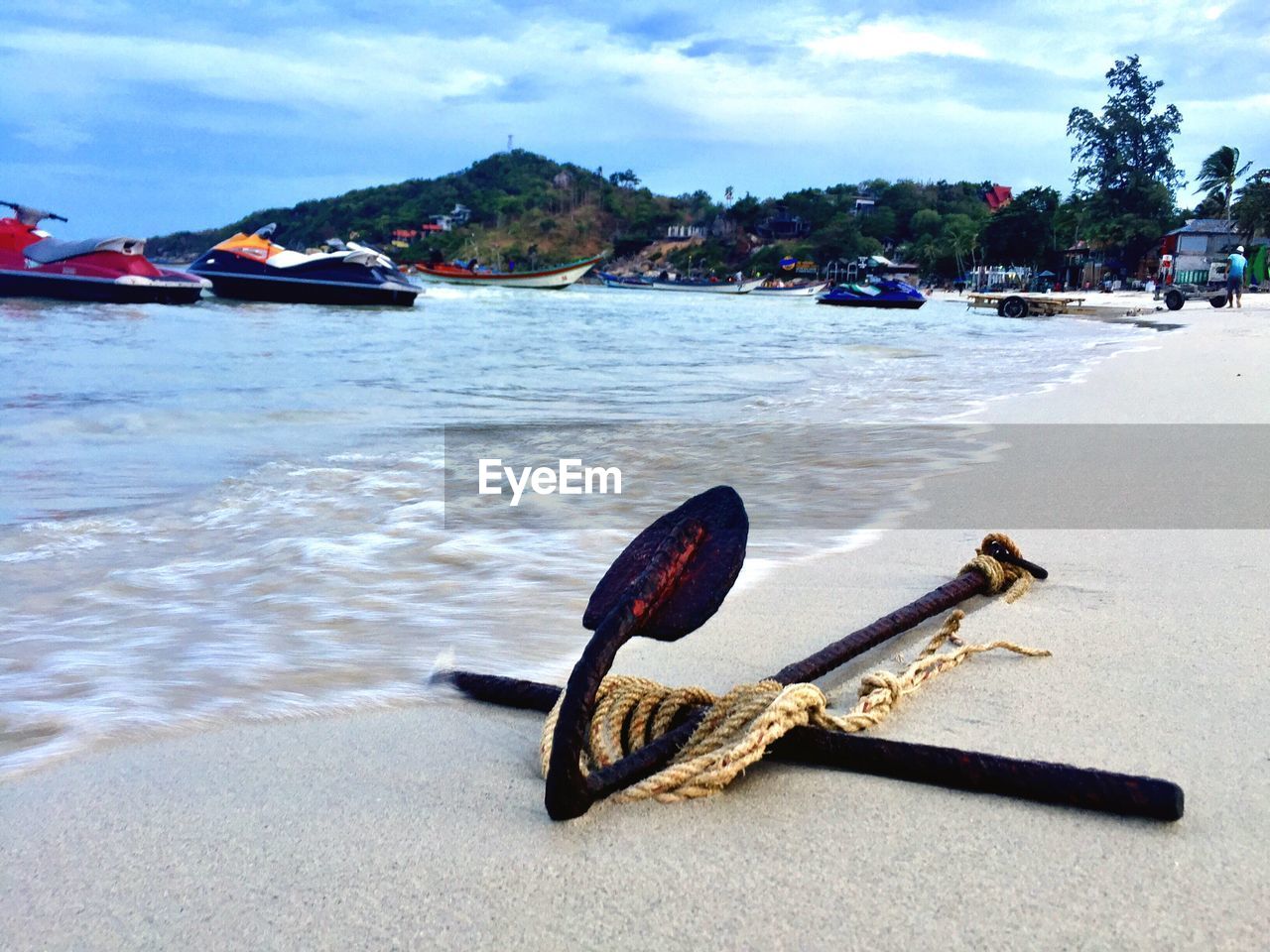 BOAT MOORED AT BEACH AGAINST SKY