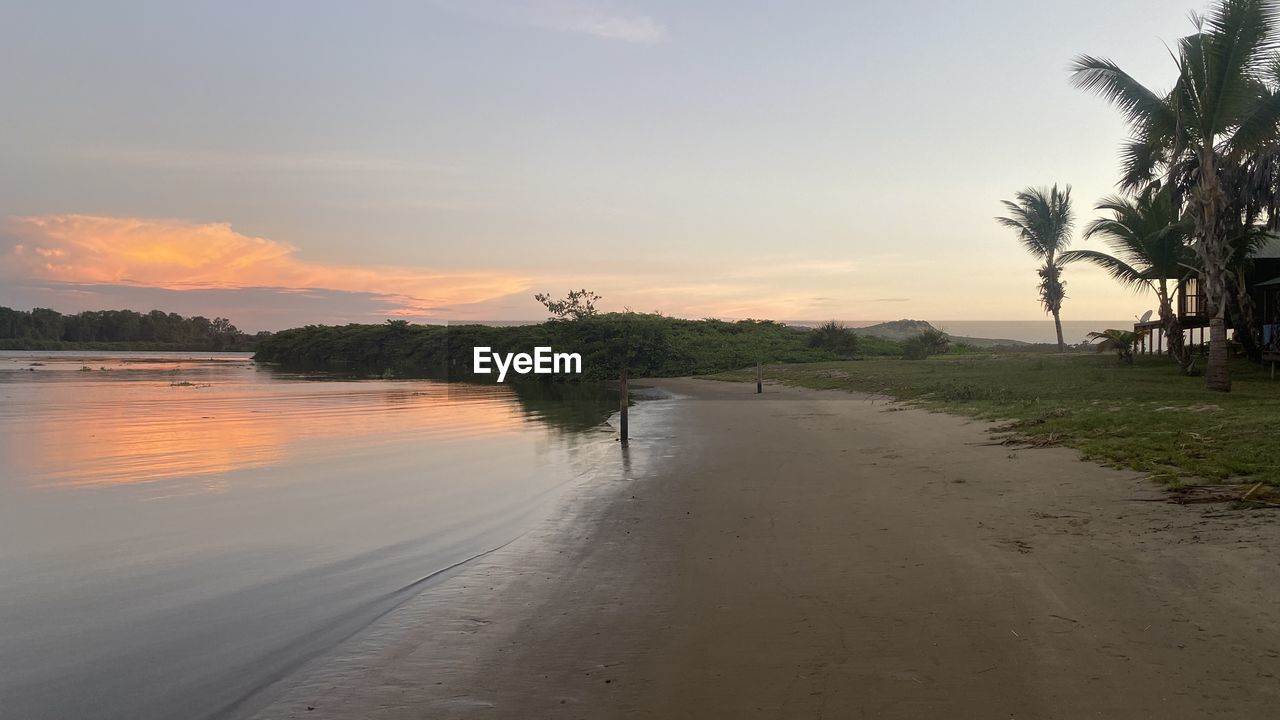 SCENIC VIEW OF BEACH AT SUNSET