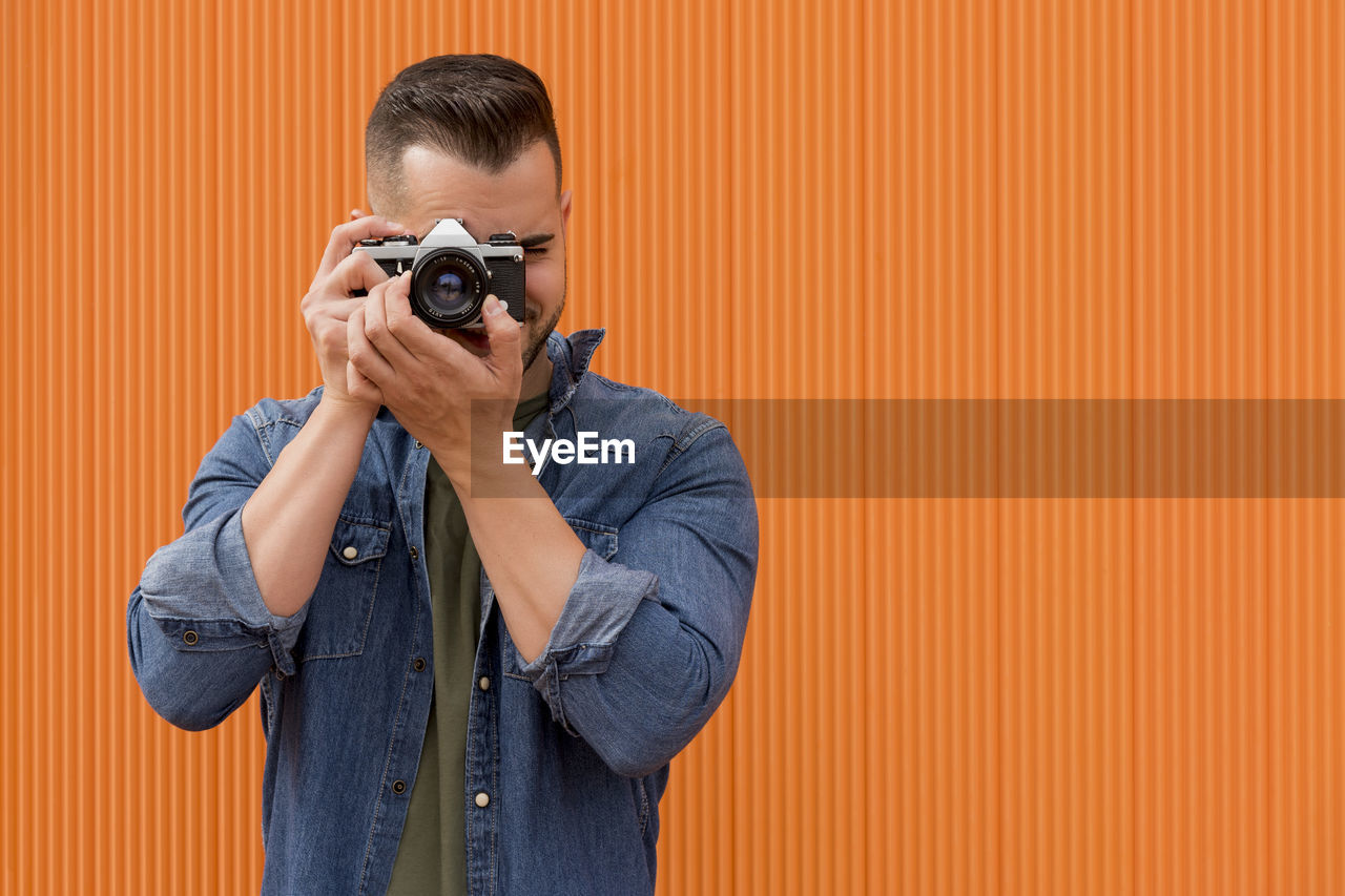 Portrait of a young man taking a photograph