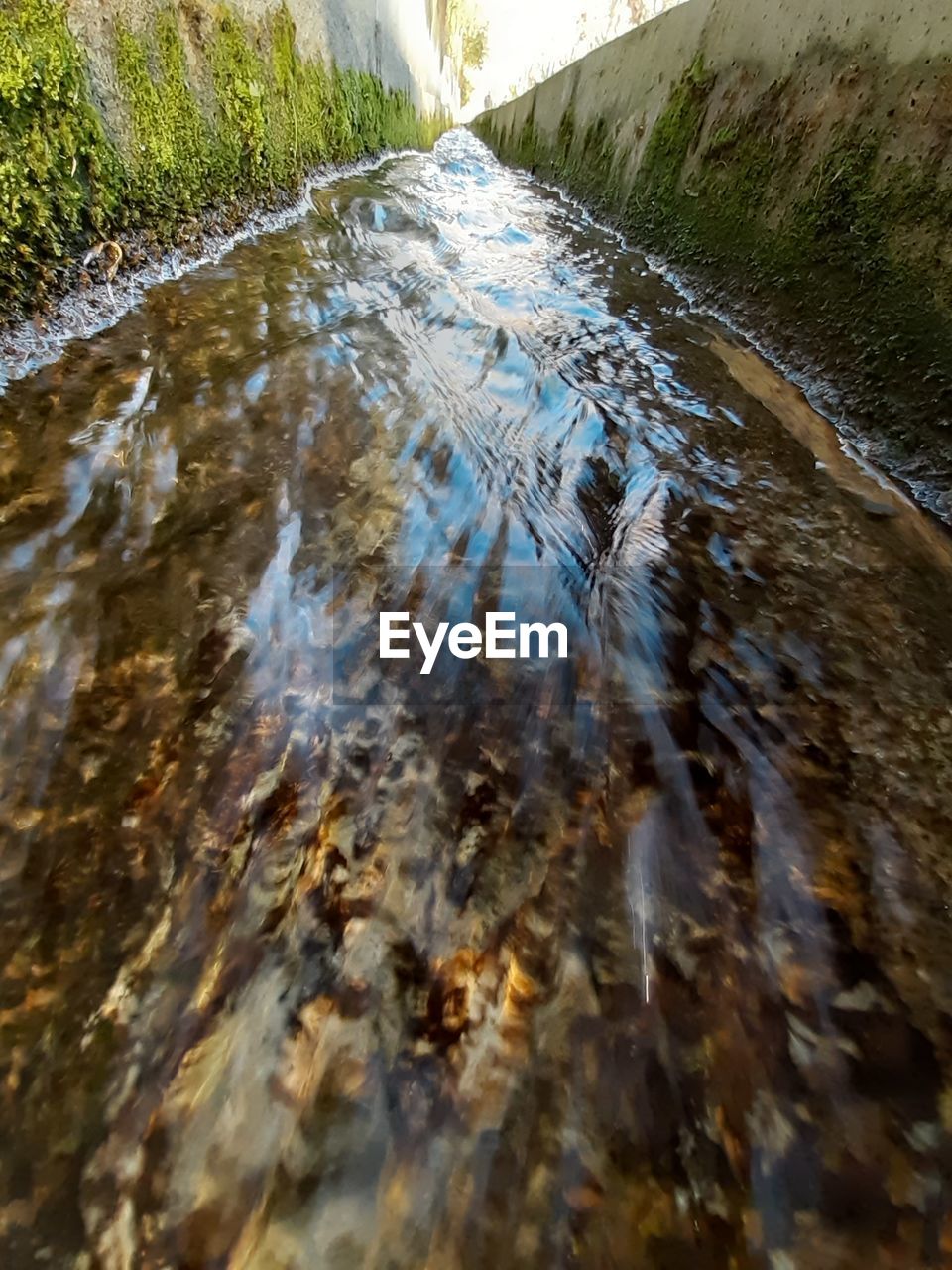 CLOSE-UP OF WATER FLOWING OVER RIVER