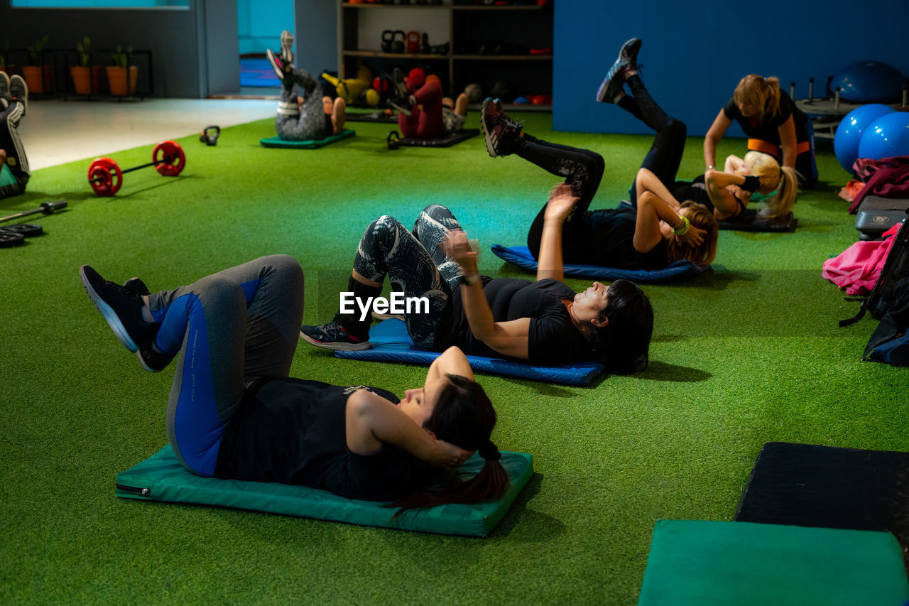 High angle view of people exercising abs at the gym
