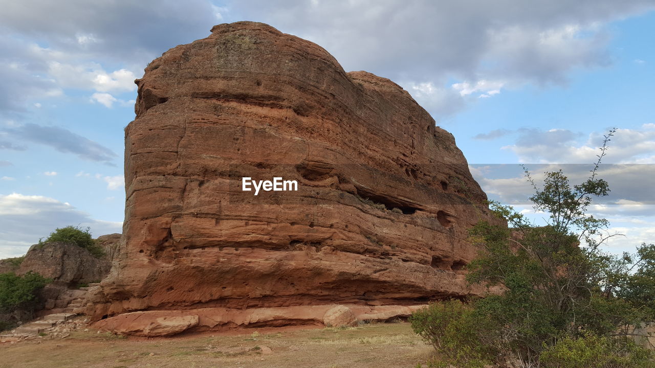 LOW ANGLE VIEW OF ROCKS ON MOUNTAIN AGAINST SKY