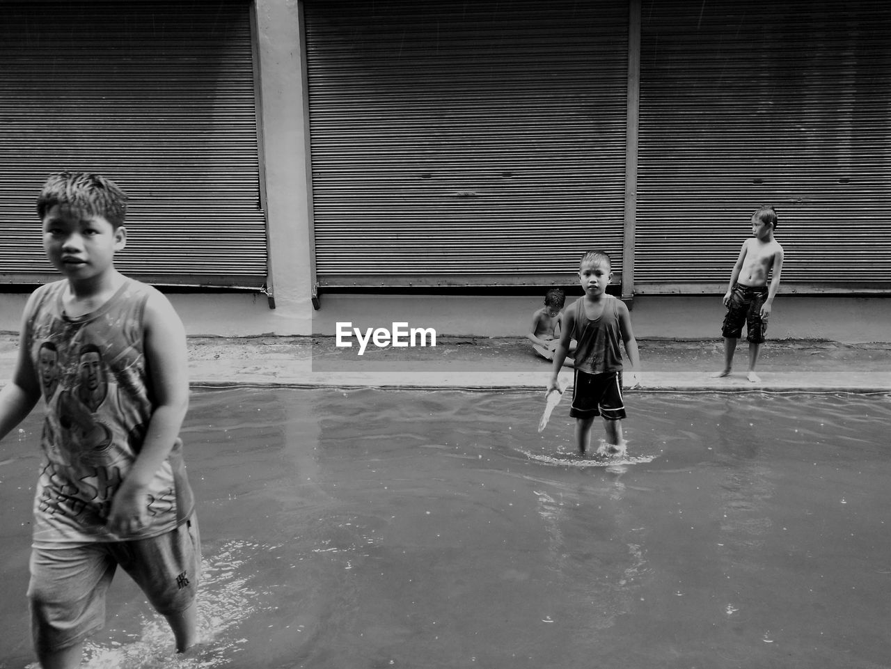 FULL LENGTH OF BOYS STANDING ON WATER