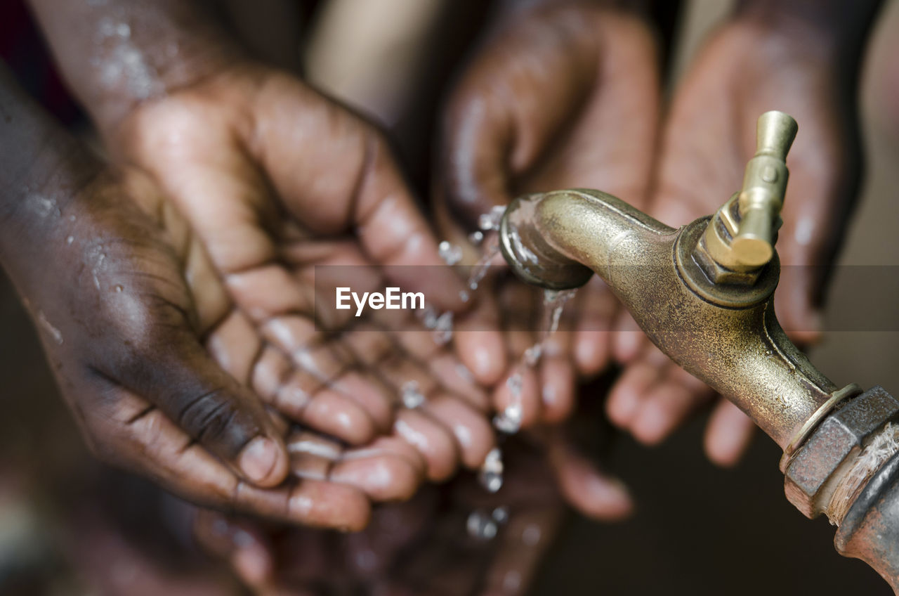 Close-up of hands under falling water from faucet