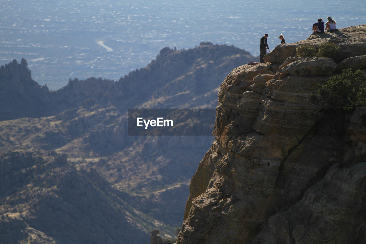 People on rock by mountains tucson arizona