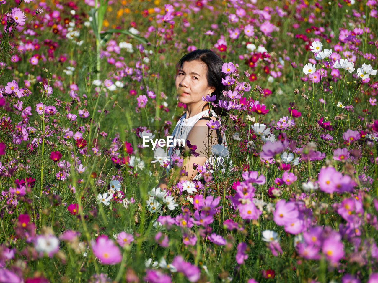 Portrait of smiling woman with pink flowers in bloom
