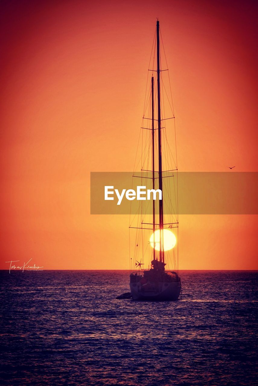 SAILBOATS SAILING IN SEA AGAINST SKY DURING SUNSET