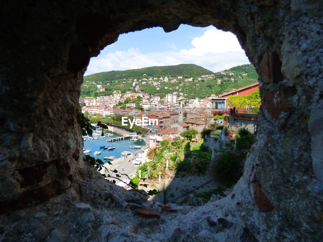 HIGH ANGLE VIEW OF TOWNSCAPE AND MOUNTAINS SEEN THROUGH ARCH