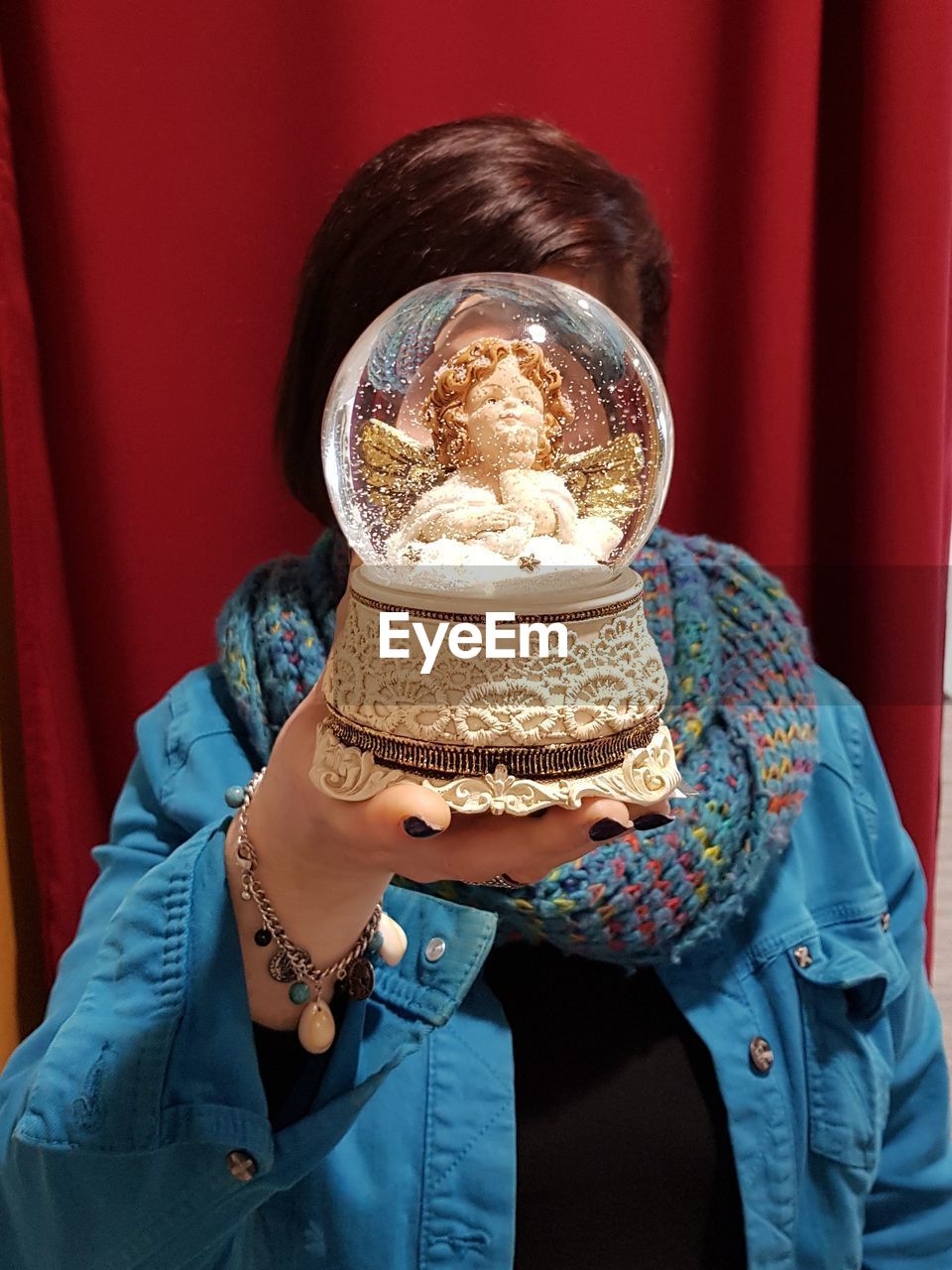 Close-up of woman covering face with snow globe