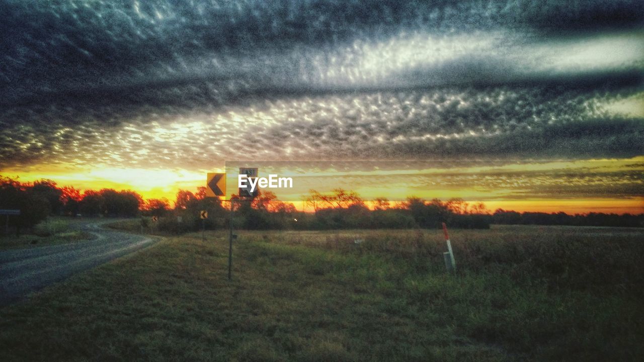 SCENIC VIEW OF LANDSCAPE AGAINST CLOUDY SKY AT SUNSET