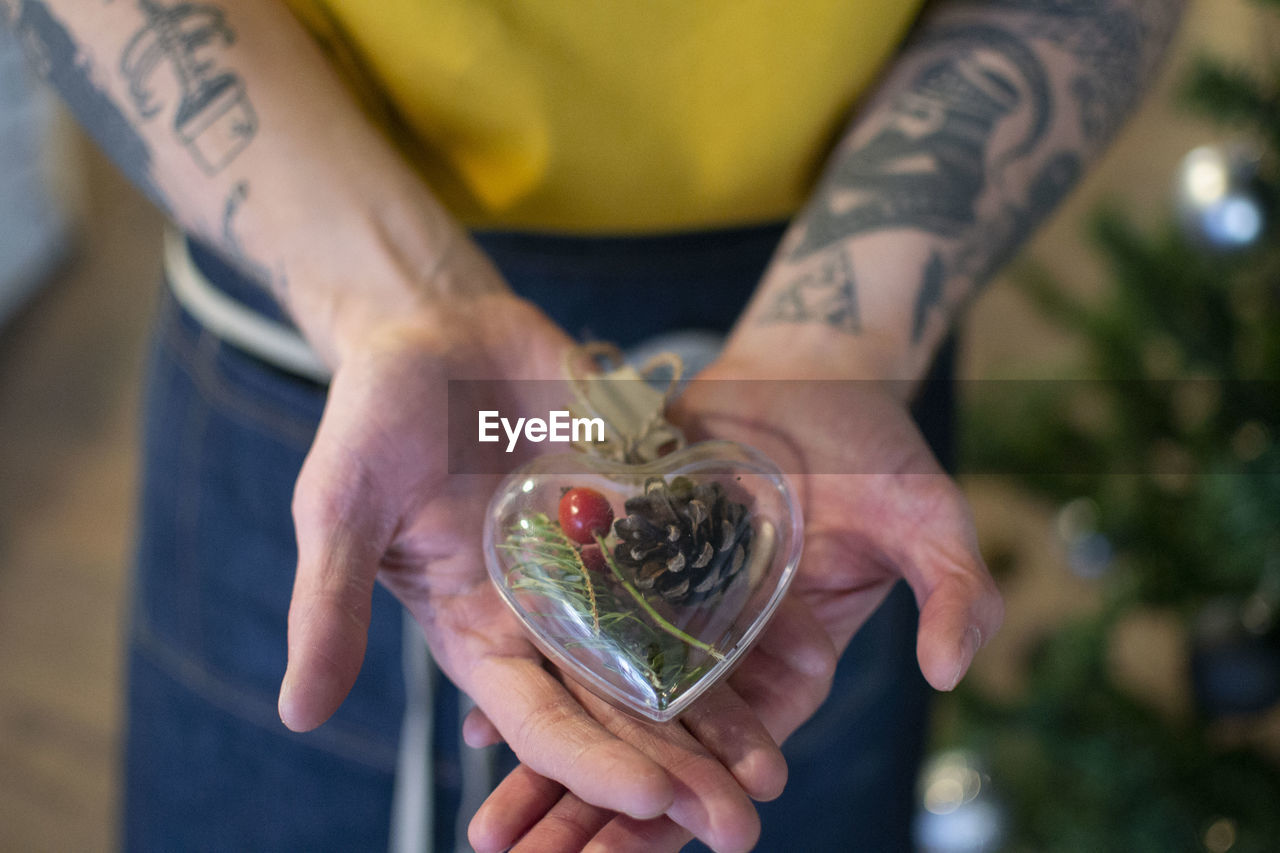 Midsection of man holding heart shape decoration