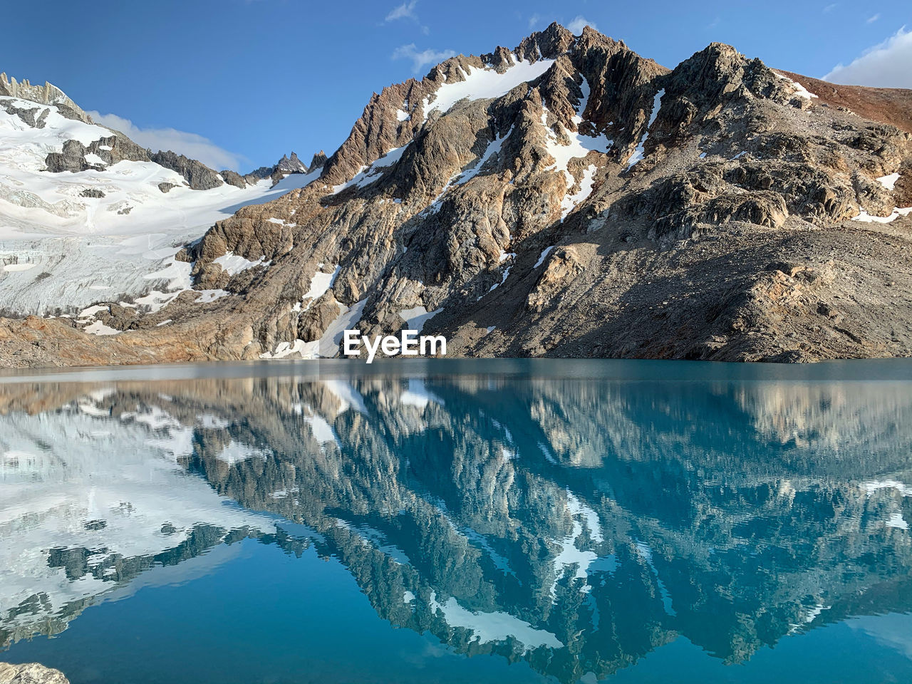 Scenic view of snowcapped mountains and lake against sky at fitz roy lookout point el chalten