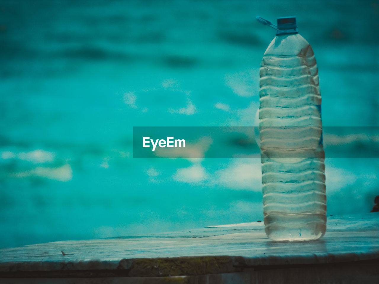 CLOSE-UP OF BOTTLE ON TABLE