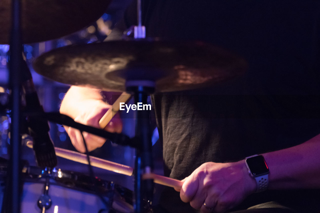 CLOSE-UP OF MAN PLAYING MUSIC AT NIGHTCLUB